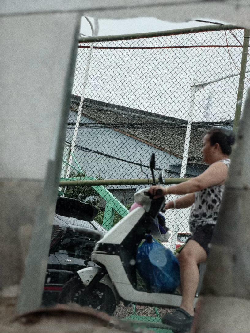 在路边等人，观察一面被废弃的玻璃中人来车往的影像。照见的是一瞬的皮囊，照不见的是