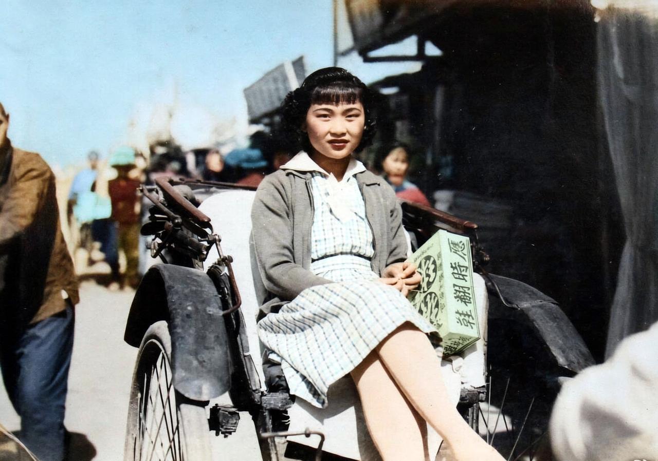 在侵华日军私人相册中发现在一张老照片，画面上是一名身份不明年轻女子，她坐在人力车