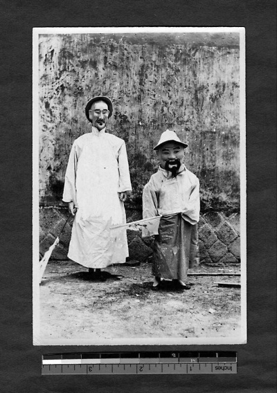 1911年-1913年间。在游神活动中戴着七爷、八爷面具的福州人 