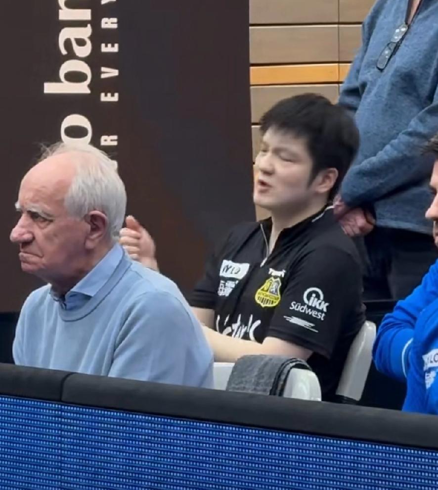 樊振东出战今日德甲联赛。
第一盘3-1战胜，库比克后，回到座位上休息。然后就开始