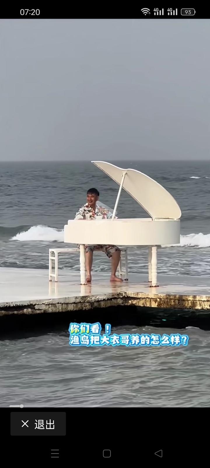 朱之文在海滩赤脚弹钢琴，会不会弹没人知道，只看到他在这里一本正经的弹奏，我就不明