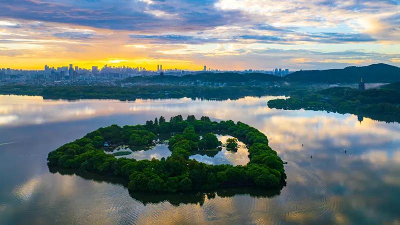 浙江省杭州市美景。
西湖出现美丽朝霞。天空如画布般铺展，绚丽霞光倒映在波光粼粼的