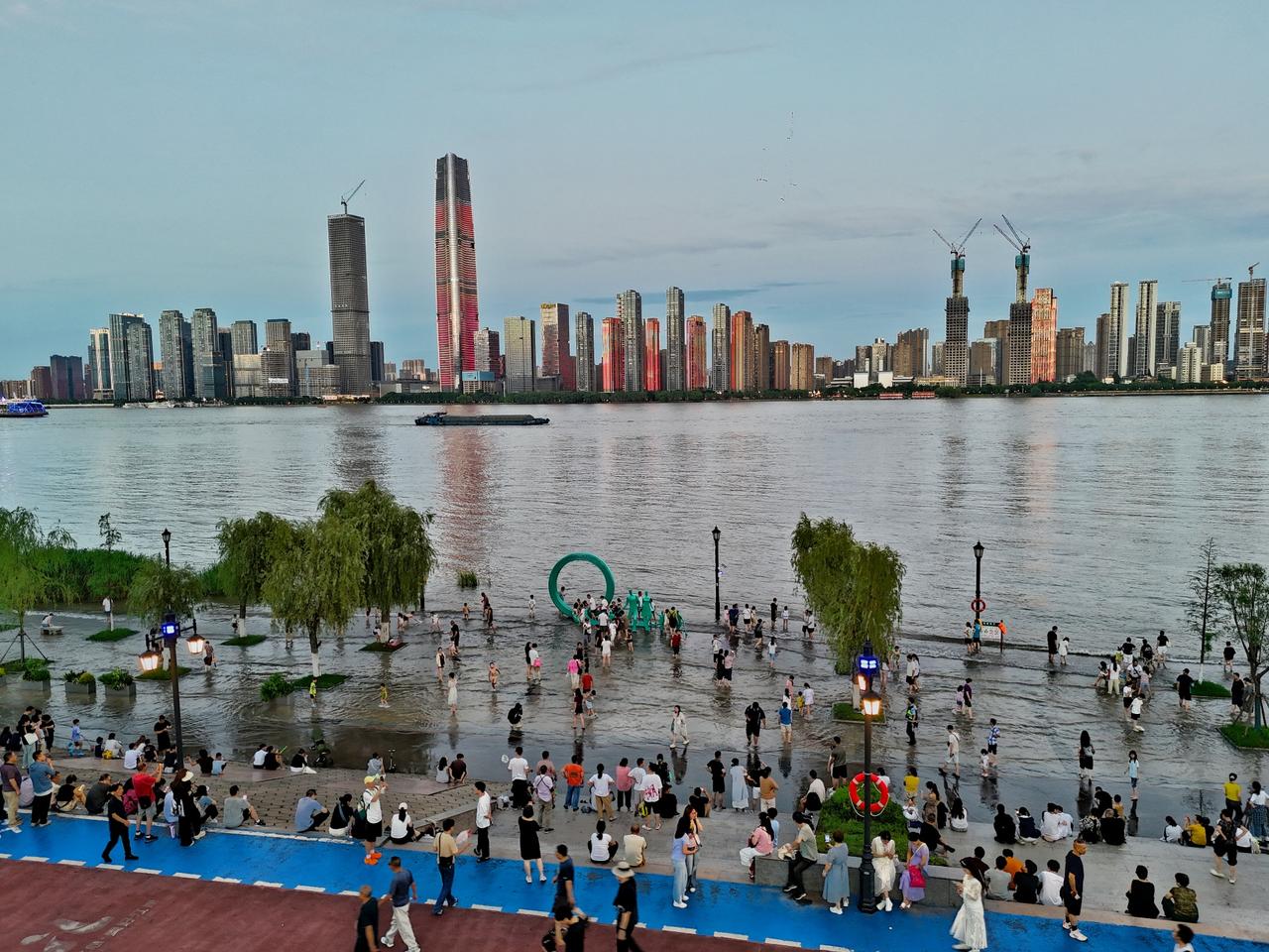 【汉口江滩一家五口雕塑游人如织】7月8日傍晚，长江汉口站水位突破设防水位。汉口江