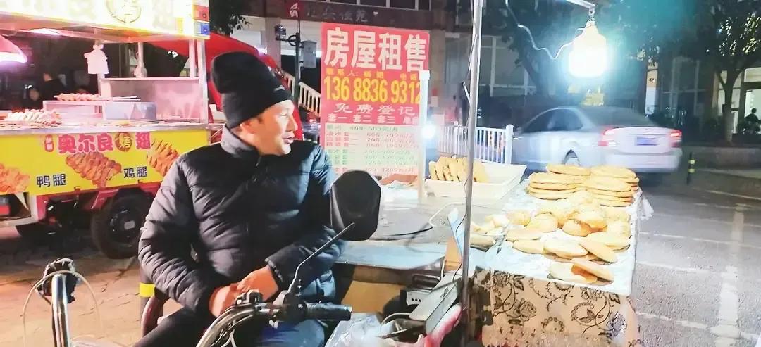 飞愉愉下班路过成都小区门口，闻到热馕香就凑过去，摊主是个和田大叔，普通话带腔却笑