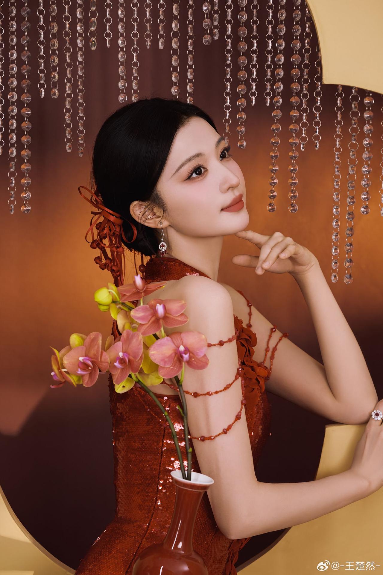 王楚然
珠串垂成一帘星子
把暖光滤成碎银
她的红裙是一捧燃烧的琥珀
亮片在褶皱里