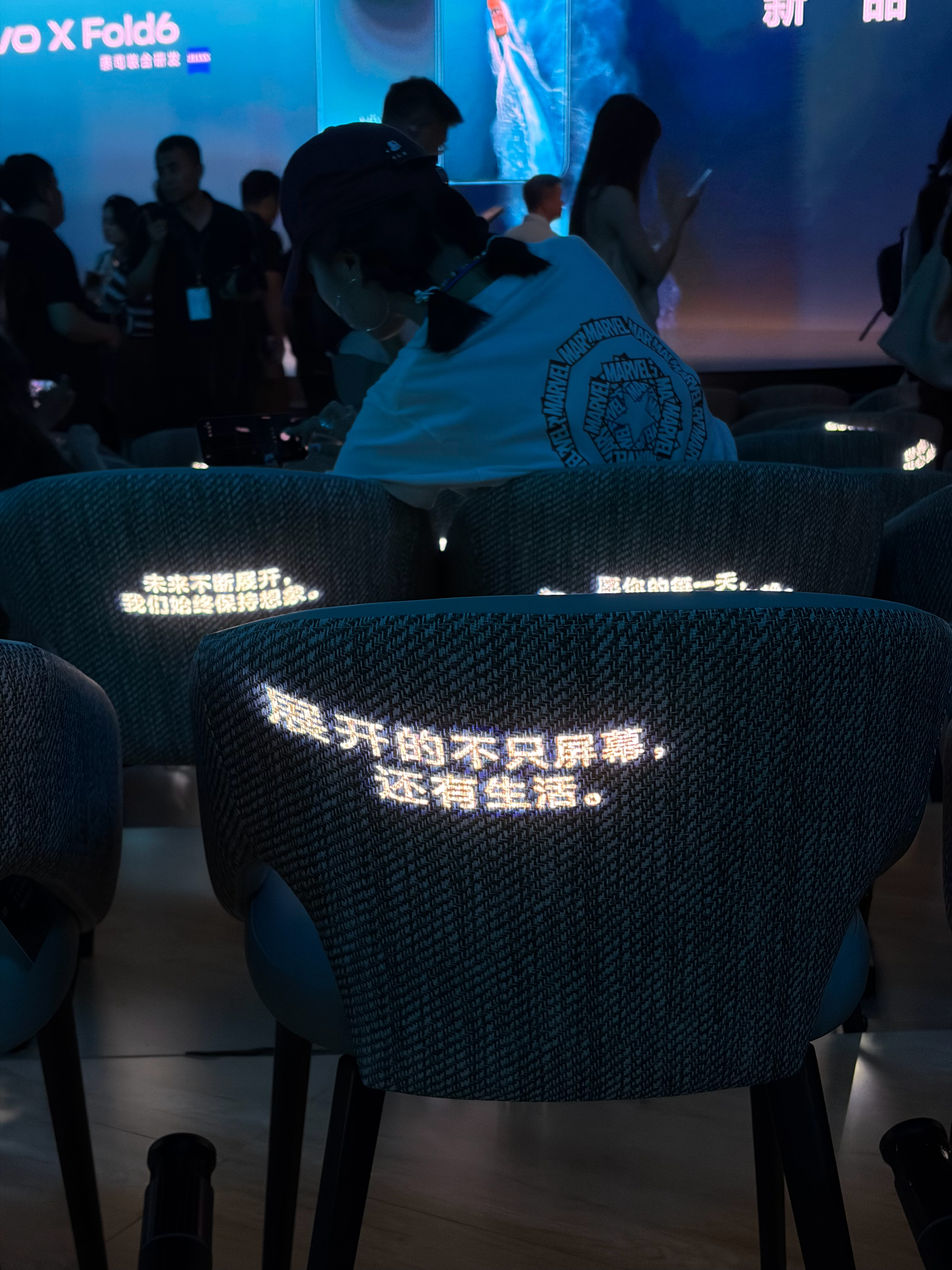 vivo X Fold6 发布会散场之后，灯光暗下来，椅子靠背上开始投影文案。"