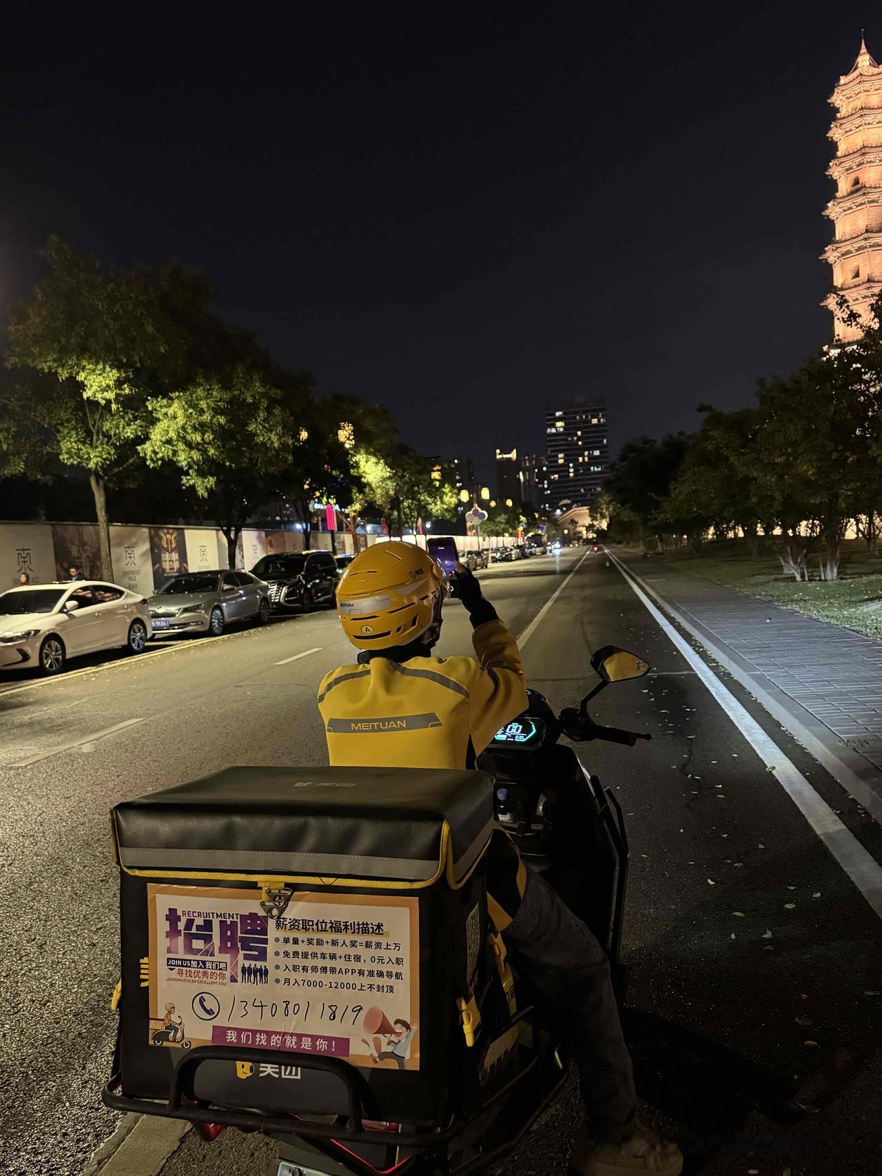 中秋夜，大同古城墙下，一快递小哥停下摩托车，认真地拍天上的月亮，然后低头捣鼓了半