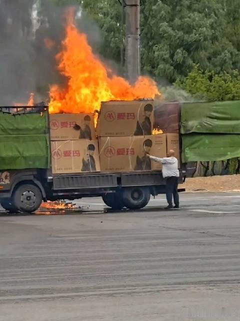 一辆满载“爱玛”电动车整车的货车正在猛烈燃烧。从浓烈的黑烟和巨大的火焰来看，火势
