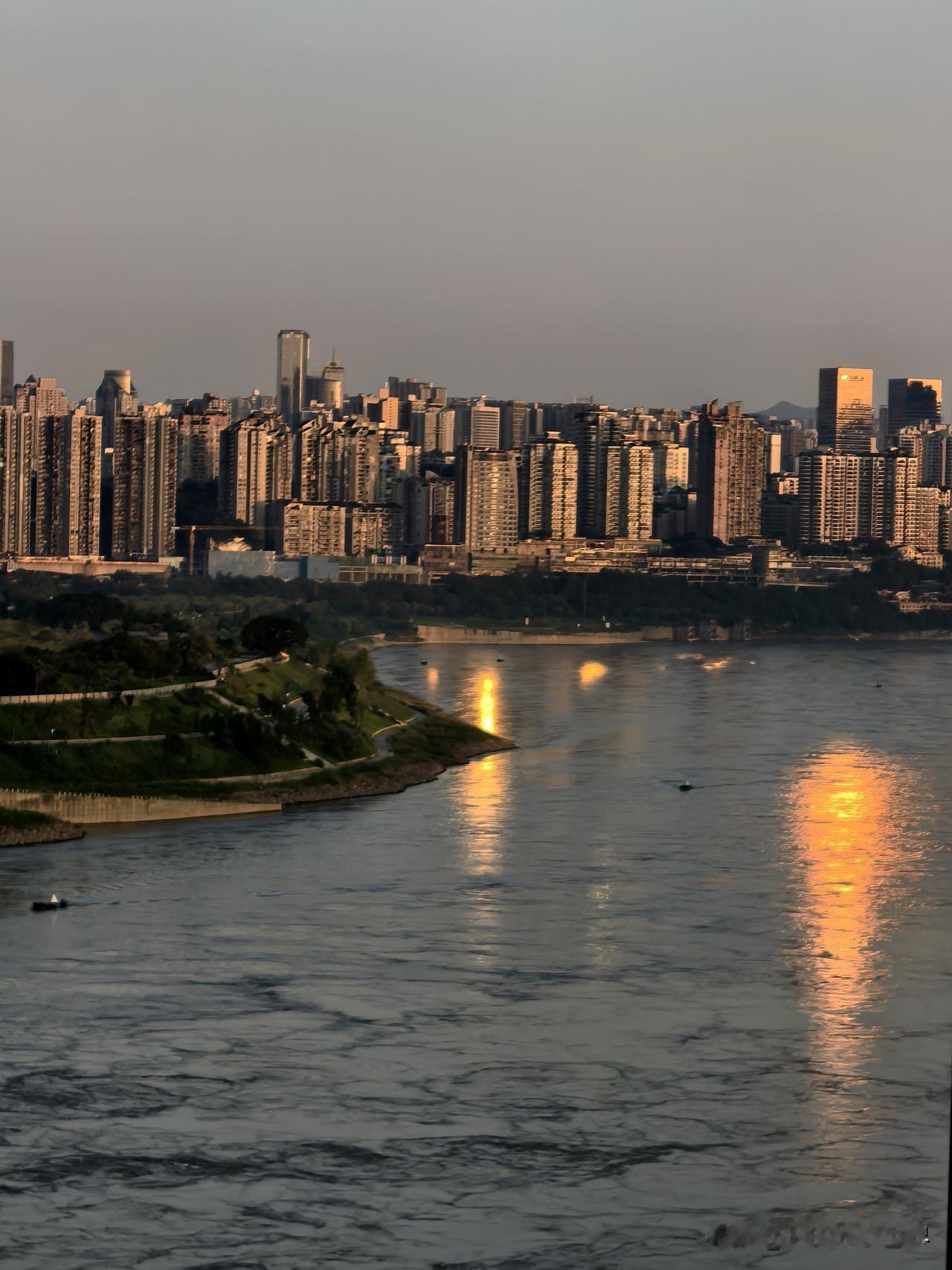 重庆的夏天:朝阳唤醒了城市，江的那一边的城市天际线，奔流的江水倒映着大楼大厦金色