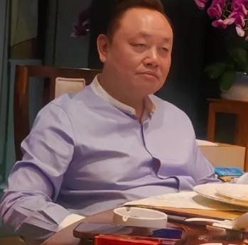 黄光裕与朋友聚餐的一张照片。他神情低沉凝重、眉头微皱，目光停滞，没有笑意，整体感