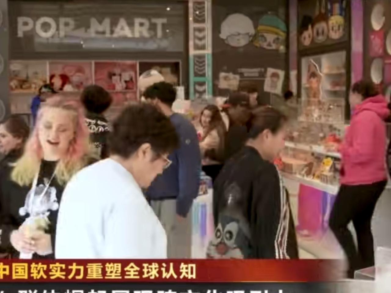 泡泡玛特门店前，外国游客驻足流连、好奇打卡，指尖翻看潮玩手办，脸上满是惊喜。中国