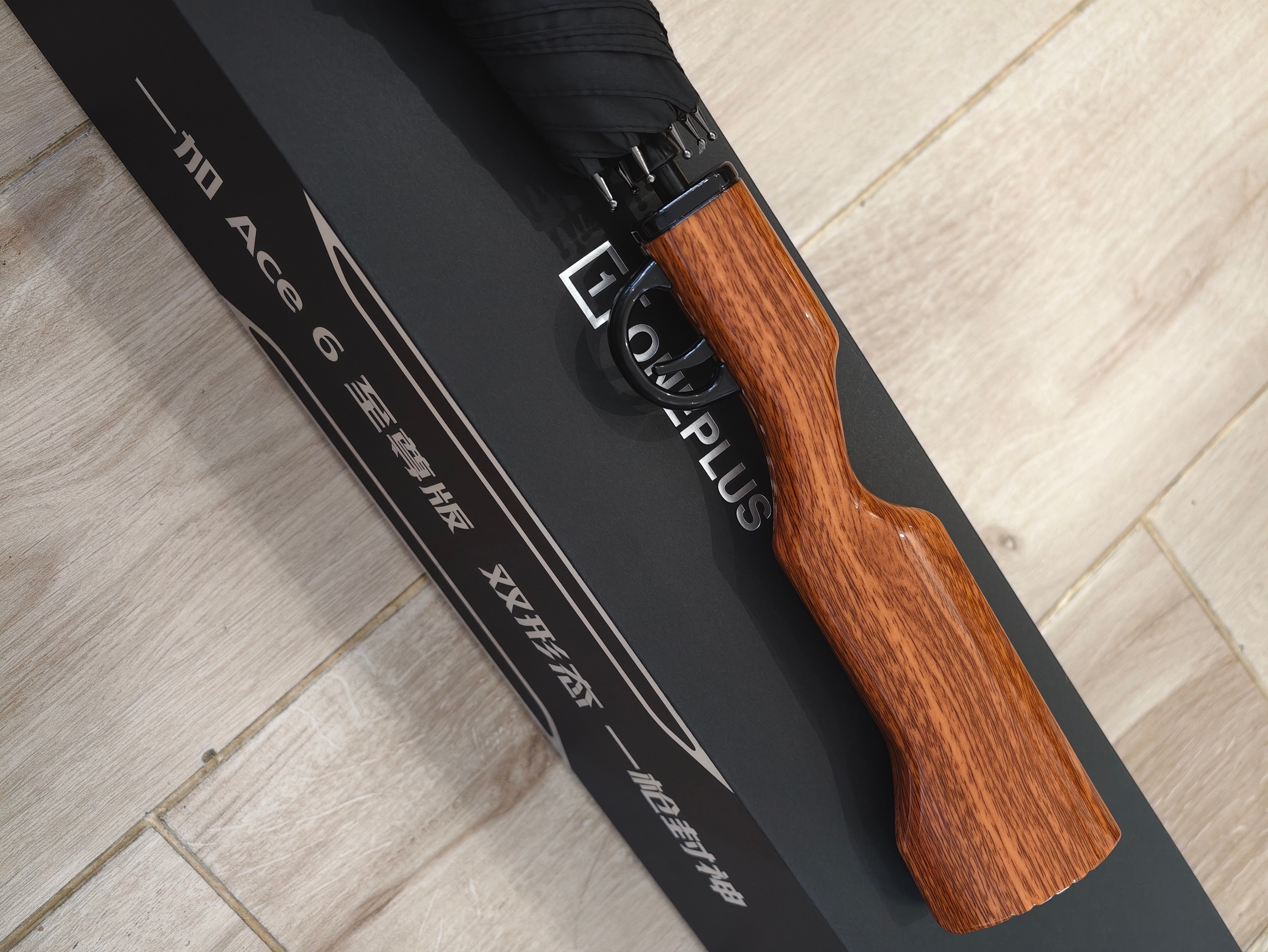 一加 Ace 6 至尊版邀请函有意思，是一把枪型手柄雨伞，玩射击游戏就选一加！ 