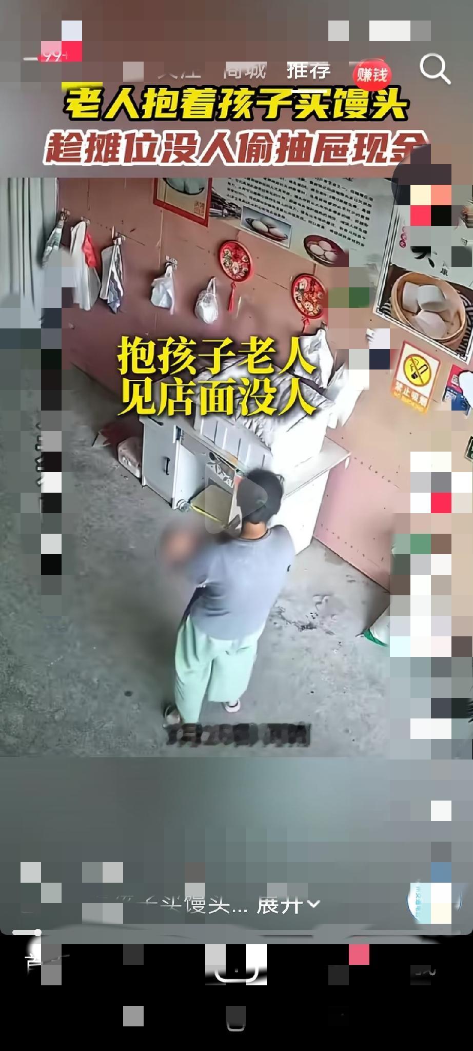 近日，一名怀抱幼儿的老人，趁摊主不在场，快速伸手拉开抽屉拿走里面的现金后揣进兜里