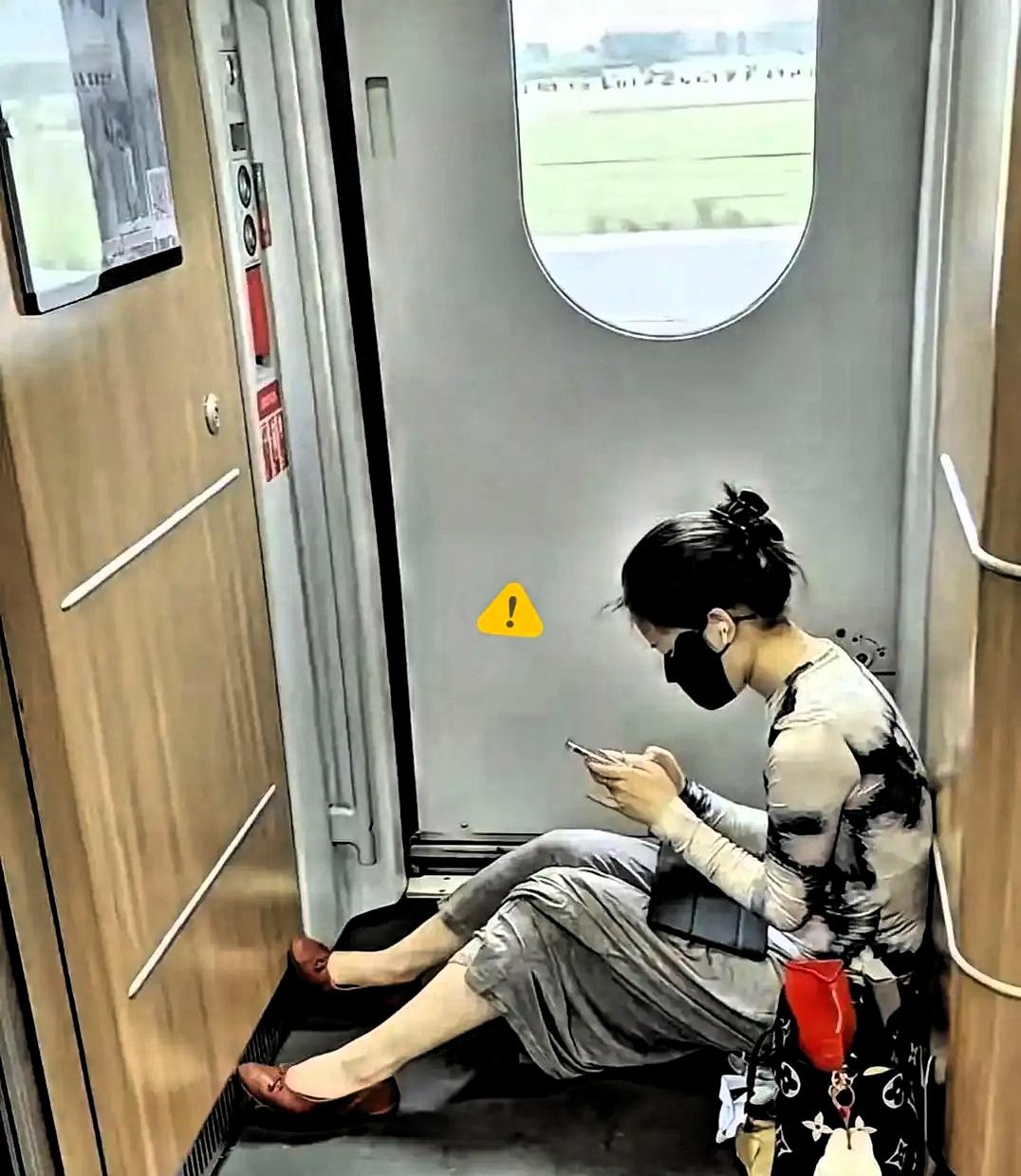 高铁上，一个买了无座票的姑娘，默默坐在车厢连接处的角落里刷手机，全程安分守己，不