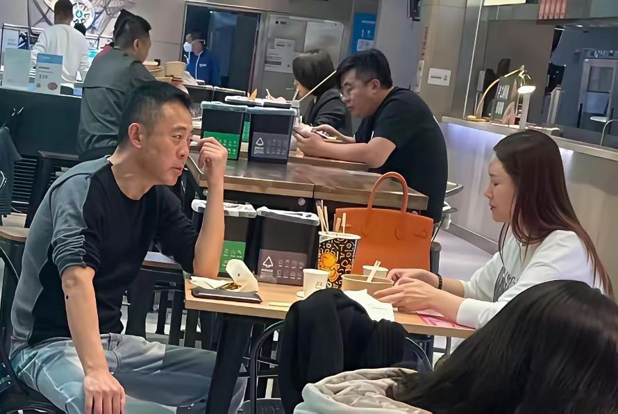 侯勇和三婚小娇妻王瑞在外就餐时的一幕，小娇妻一头长发青春靓丽，桌上放着一只橙色爱