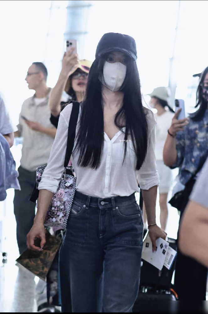 白衬衫，牛仔裤，蔡依林往机场一站，全网又在研究她怎么就能穿得这么不费劲。

可你翻翻她过往的机场图，哪回是真随便？2019年那套，oversize外套里裹着紧身马甲，宽大剪裁里藏着火辣心机。看着松，其实处处是算计。这回的复古牛仔裤配亮片包，也是同一个路数，拿捏的是我根本没用力的错觉。

真松弛的人，