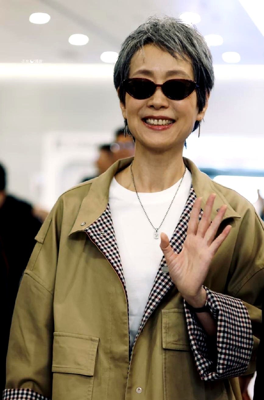 60多岁的叶童在机场露面，满头银白头发愣是一点没染。

戴着墨镜，一身宽松卡其色工装，袖口卷起来露出格纹，脚上亮黄色袜子配暗红色包，走起路来带风。她脸上的褶子没填，肚腩没死命勒着，就这么坦坦荡荡走在镜头前。

现在不少上了年纪的，穿衣容易走向两个极端：要么把自己往花里胡哨的大妈碎花里塞，要么疯狂做医