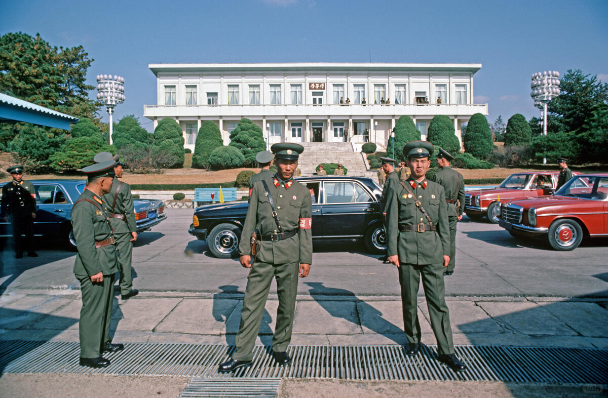1983 年，朝鲜与韩国在板门店举行会晤，板门店位于非军事区。桌子中央垂下的一条电缆象征着边界。 ​