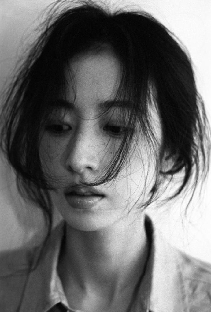 周雨彤黑白胶片写真，真实感才是顶配
看多了精修完美的明星大片，周雨彤这组黑白胶片人像，反倒让人眼前一亮。摒弃华丽布景与浓妆包装，纯白简洁背景搭配复古胶片颗粒感，剥离所有色彩修饰，只用光影记录最本真的状态，温柔又有张力。
这组写真主打极致松弛的纪实风格，全程伪素颜出镜，坦然保留脸上细碎雀斑，妆容干净通