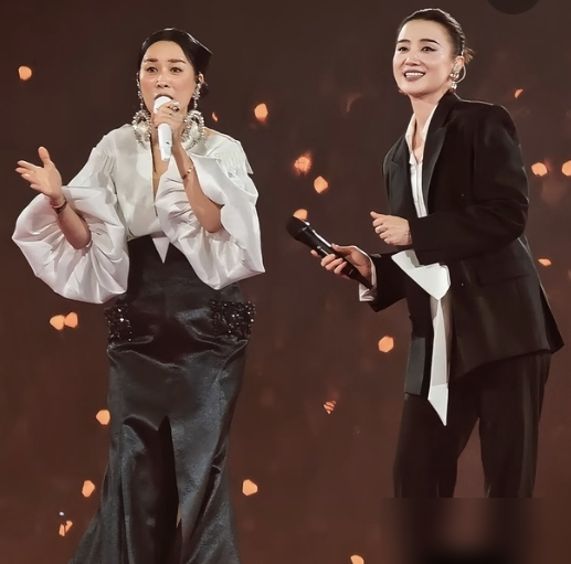 那英演唱会直接点名王菲：把手举起来，我故意的。
8月22日五棵松，王菲躲包厢吃棒棒糖，被那英当众拎出来。喊话声刚落，王菲乖乖举双手晃荧光棒，眼镜都摘了。花篮落款老王，写着先干为敬。
这俩人的账，得从1998年算。那英被雪藏，王菲塞经纪人、拉她共用化妆间、连老公都是王菲牵的线。那英回头就在王菲走音