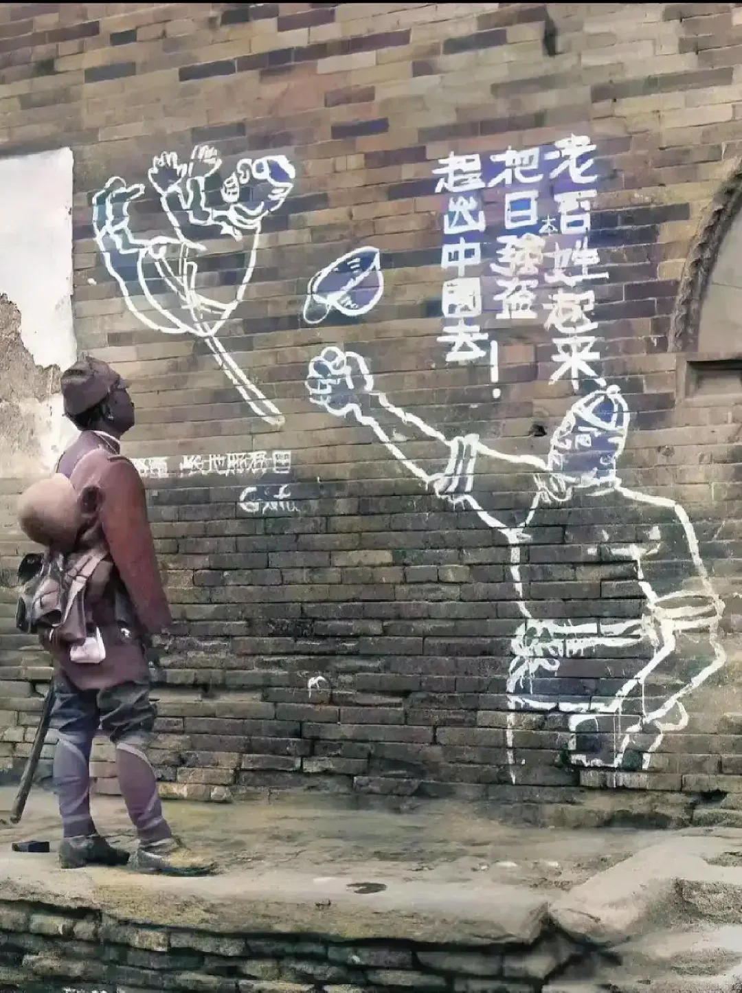 一个矮小的日本军人正在对着墙画傻看着！
