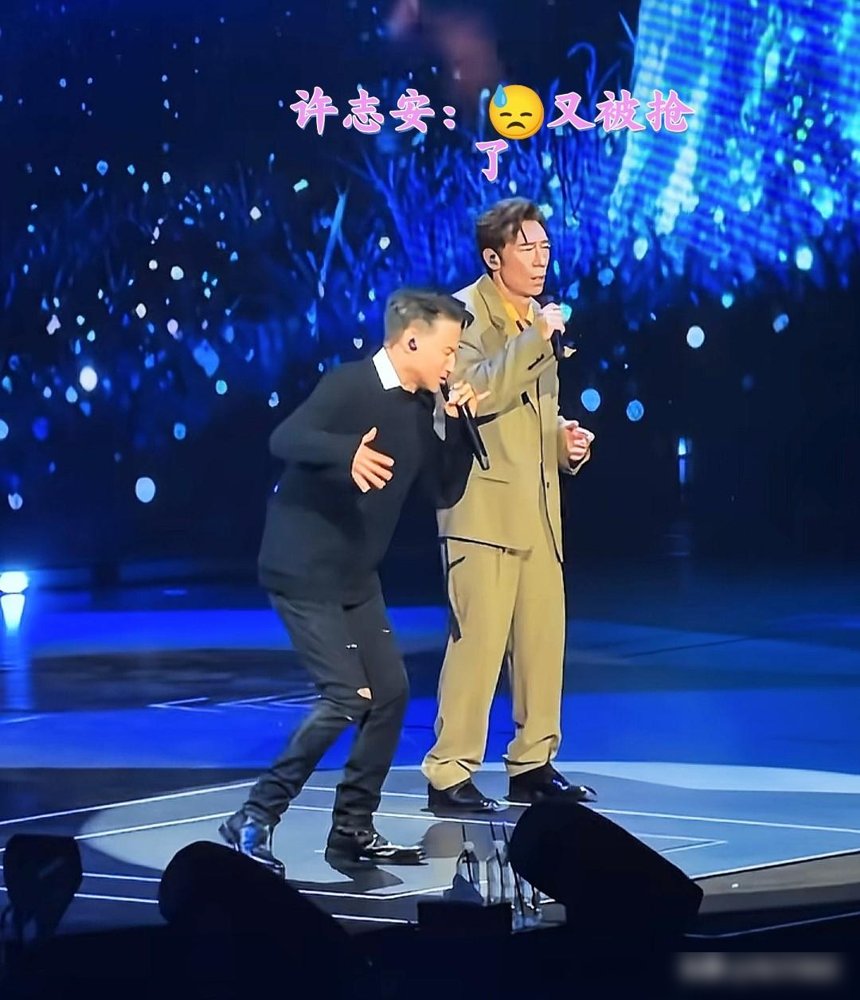 张学友一开口，许志安彻底成了背景板。
64岁，破洞牛仔裤，红馆连唱12首不带喘。安可环节《吻别》直接上摇滚版，台下一堆老牌明星全站起来。
镜头扫到许志安，复古造型站旁边，话筒举了三次，嘴刚张开，歌神的调门又压过来了。全程愣是插不进一句。那表情，活像憋了个大招没放出来。
旁边人唱到缺氧，他站到内