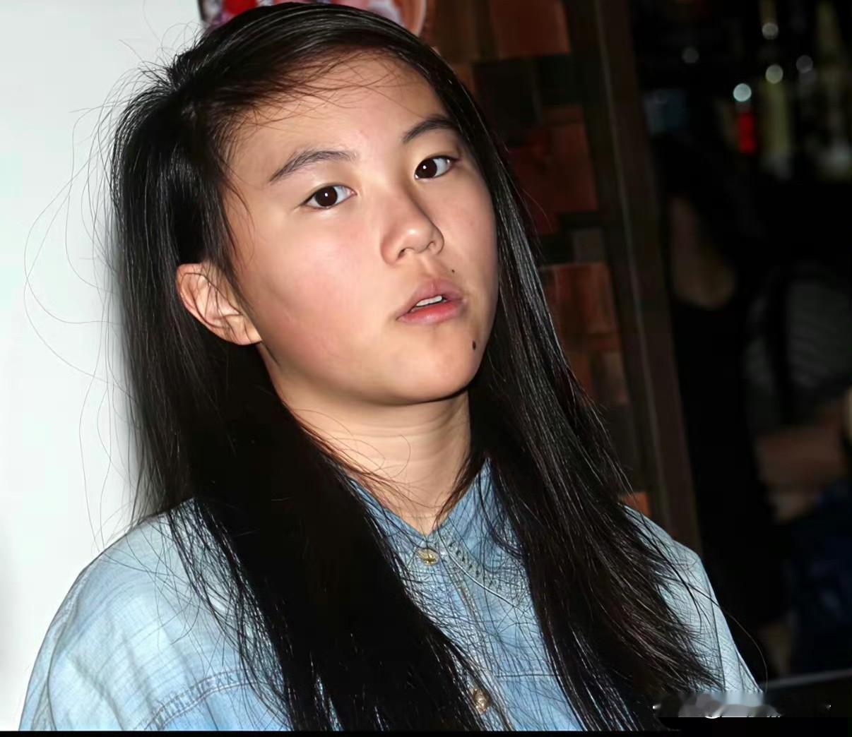 说实话，
窦靖童的心病不是自己的长相，
而是那句永远摆脱不掉的称呼！


窦靖童的长相，从出道吵到现在，
爹妈都是神仙颜值，到她这儿画风突变，
喜欢的网友说高级有味道，
不喜欢的直接说没长开，
两边吵了十年谁也没说服谁。


你看她这张旧照，
十几岁，长头发，牛仔衫，
安安静静看着镜头，
嘴角那颗痣