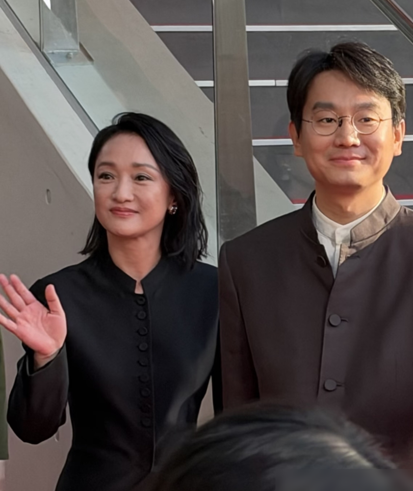 51岁的周迅，生图直接甩出来了。釜山红毯上，香奈儿高定全球首穿，配一头短发，脸上该松的松，该垮的垮，一点没遮。旁边站着71岁的奚美娟，一身素色长裙，盘发利落，腰背挺得笔直。外网镜头不骗人，白发、皱纹、法令纹全在。有人夸这是松弛舒展，有人嘀咕周迅脸有点肿、状态发疲，反倒被大20岁的奚美娟压了气场。可这