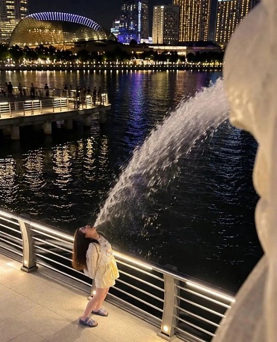#桥本环奈新加坡那组照片太火了#为什么桥本环奈新加坡这组照片会爆火？
不是精致氛围感大片，反而是一张充满趣味的游客打卡照。鱼尾狮前，大胆后仰玩视觉错位，放飞自我，偶像包袱碎了一地。
见过太多明星的旅行物料，修图完美，每一张都精致无瑕。反观她，大大方方放出充满生活感的库存，记录旅行里好 ​