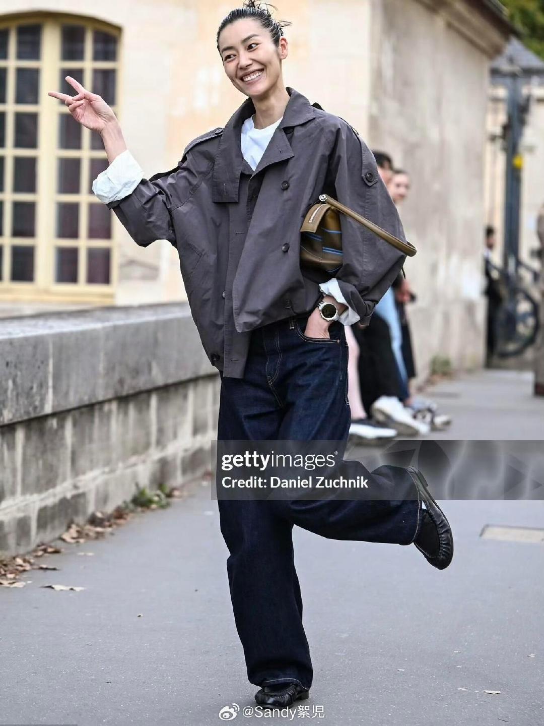 #时装周# 笑容明媚的大表姐刘雯巴黎秀场外街拍，漫步街头满是自在从容。
灿烂笑容带着一点小俏皮，瞬间被治愈
短款工装风衣叠穿白T恤，搭配原色阔腿牛仔裤。基础款简单组合，不刻意的时髦感格外抓人。随性松弛，自带高级氛围感#大秀直击##巴黎时装周# ​