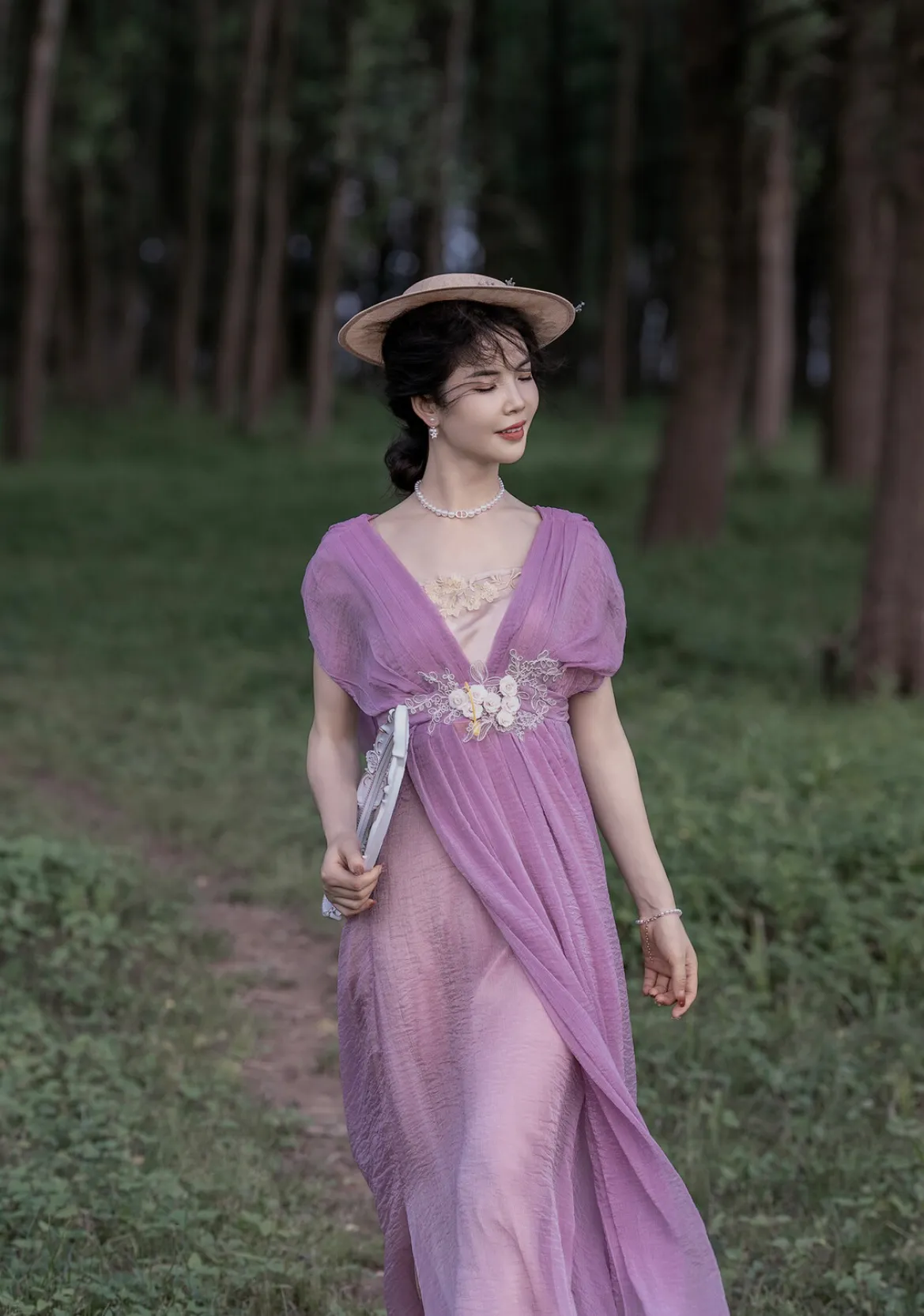 漫步森林中的优雅淑女，粉色长裙与自然风景相得益彰。