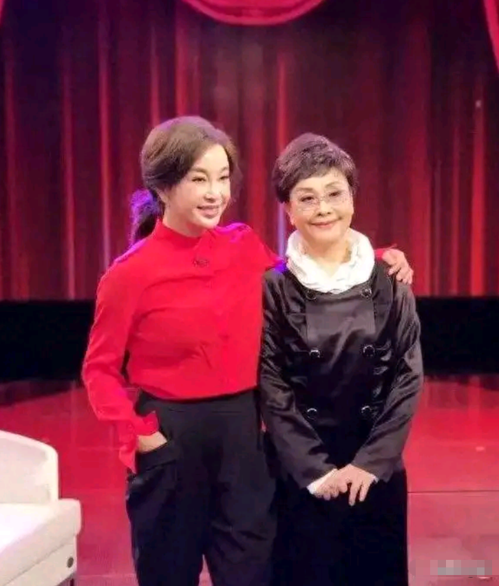 李谷一和刘晓庆同框，5岁年龄差，一个如女儿，一个似慈祥的妈妈～

两人只差了5岁，可站在一起，气质却像隔了一代人。刘晓庆一身利落装扮，神采奕奕，笑容灿烂，状态好得像刚拍完戏的女主角；而李谷一穿着素雅，头发微白，眼神温和，像极了家里那位慈祥的妈妈。

刘晓庆一生都在“往前冲”。从影后到商人，从巅峰到低