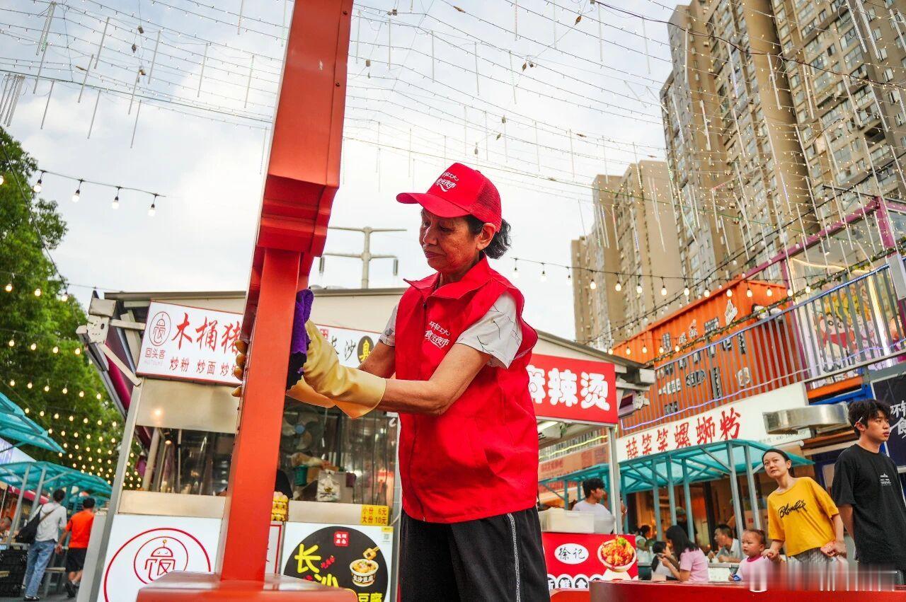 #来武汉过周末#【金银湖食光夜市火出圈了】坐落于金银湖街道马池中路11号的环轻工大食光夜市，开业短短两个多月热度持续走高，成为东西湖区新晋夜间消费热门打卡地。这片由闲置地块改造而成的特色街区，占地2000余平方米，规划设置104个规范摊位。凭借多元业态、有序环境及精细化管理，夜市日均客流量 ​