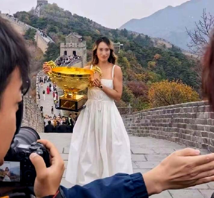 郑钦文近日现身长城拍摄中网写真，身边还跟着四位保镖护驾，现场被网友拍个正着。
 

穿着休闲高跟和吊带裙的她，明艳大气，状态好到不行。
 

回想起之前记者会上那一身略显老气的酒红色上衣，配上厚重的口红，真不知道当时是谁给设计的造型。
 

运动员私底下的审美，明明在线得很，非得整那些成熟老气的商务