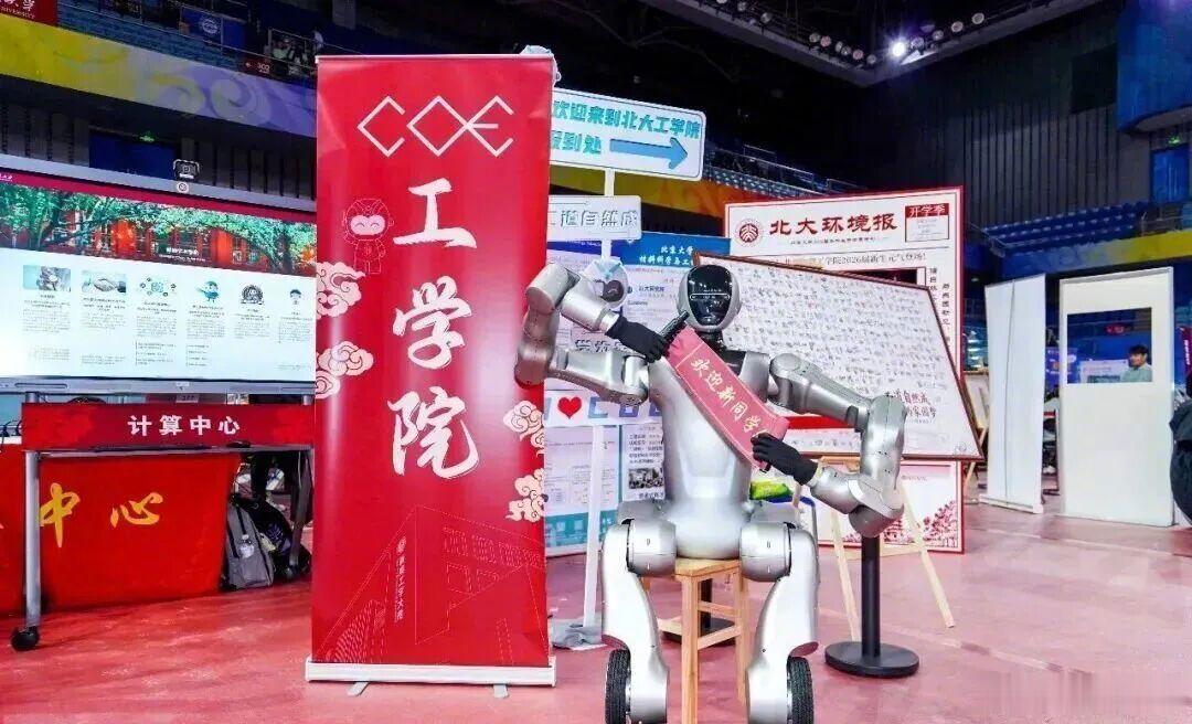 #今日最大学#  【人手一个AI“搭子”！北京高校迎新现场科技感拉满】今年秋季开学，首都高校迎新现场科技感满满。工学院报到台前，由“北大-揽月动力拟人机器人联合实验室”研发的双轮足机器人手持迎新横幅，让新生触摸科技前沿；“清小搭”依托师生团队自研的大模型和知识增强生 ​