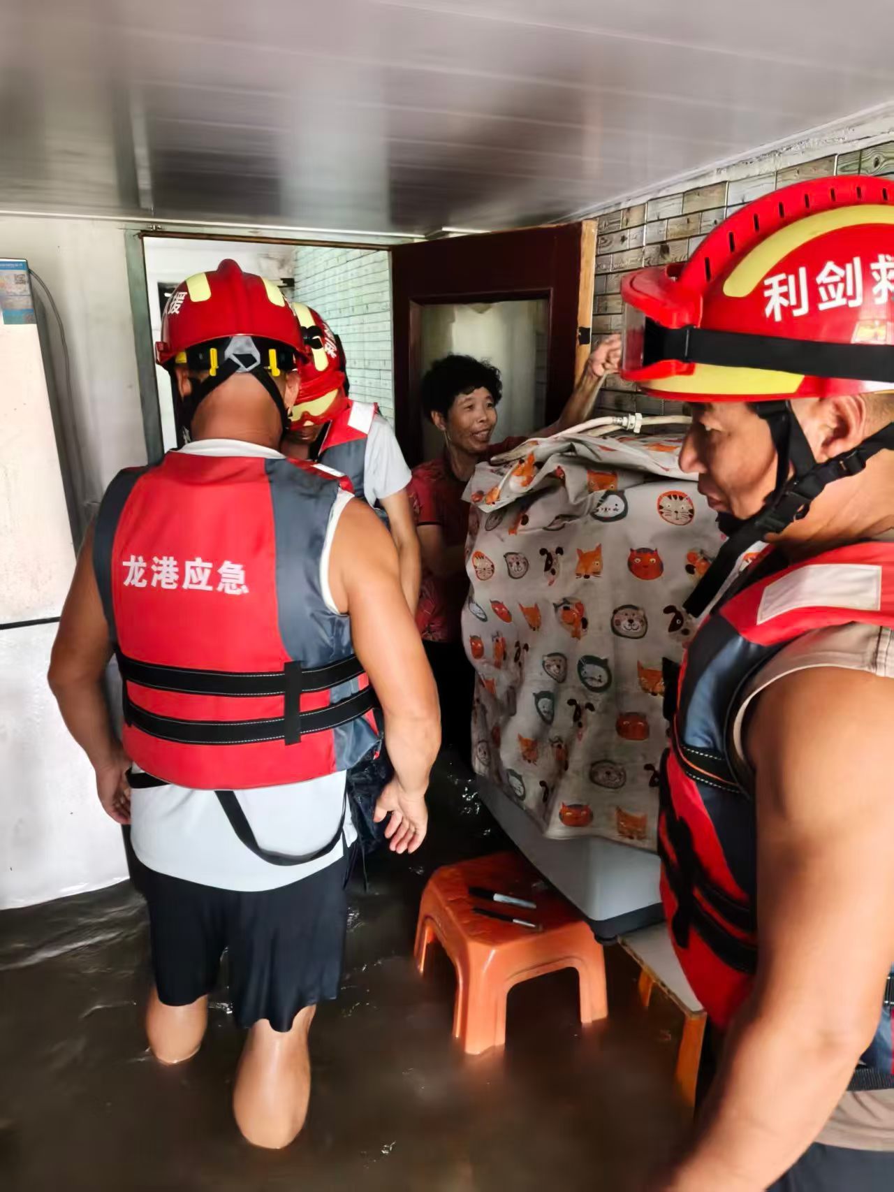 《洪水无情 人间有爱》
 ——记龙港市利剑应急救援队 作者：陈绍峰
       受台风沙德尔带来的强暴雨影响，龙港市部分农村区域出现严重洪涝，不少群众被困家中，险情紧迫。龙港市利剑应急救援队闻汛而动，队员们迅速集结奔赴受灾一线。
 
       浑浊的洪水漫过街巷，队员们身着救生衣，蹚过齐腰深的积 ​