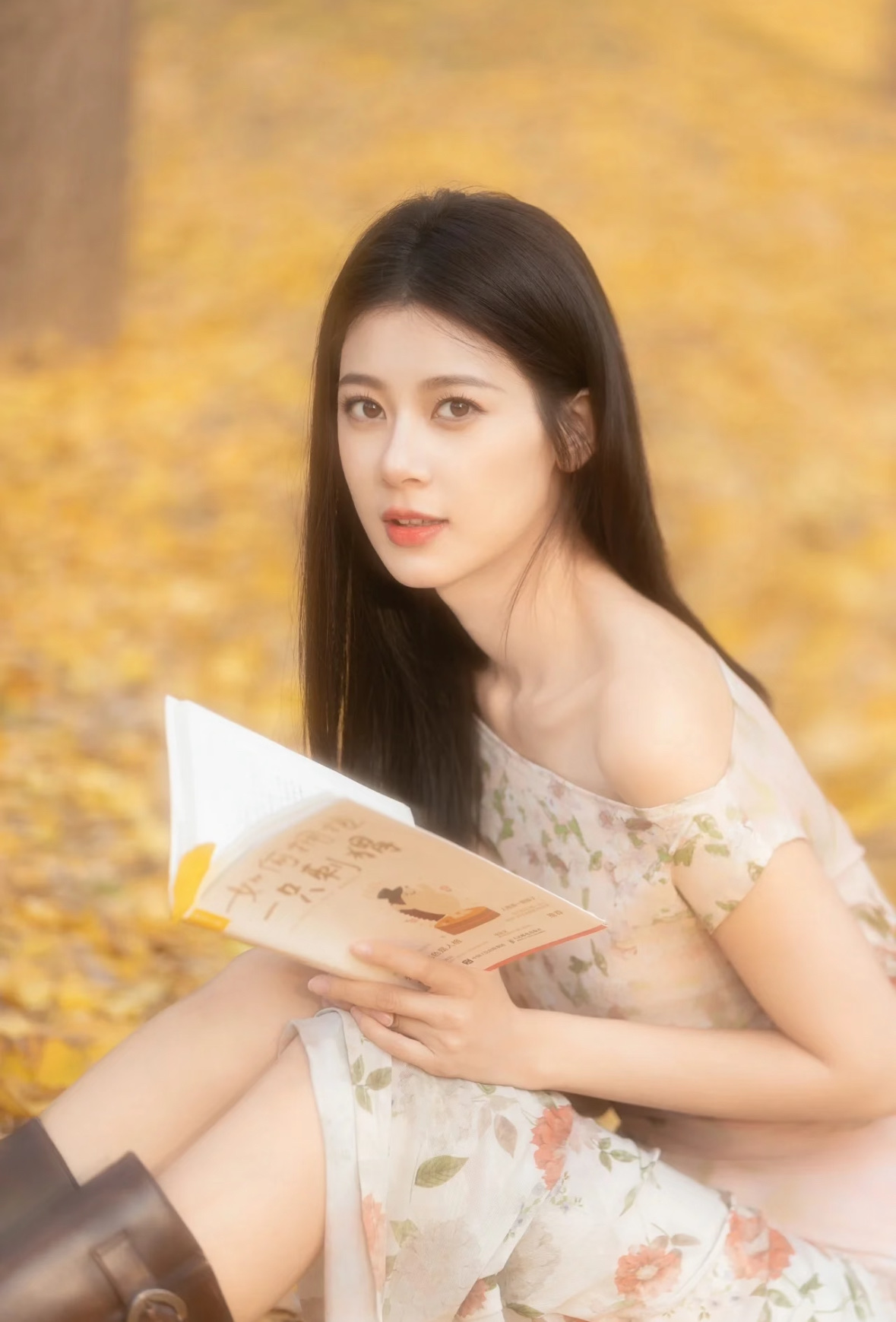 赵昭仪这组银杏秋日写真太有氛围感了🍂。满地金黄落叶，身着碎花露肩长裙，搭配复古长靴，温柔中藏着几分飒爽。手持书本、复古相机，在暖阳下漫步静坐，光影柔和朦胧。她眉眼舒展，气质松弛恬静，既有少女的清甜灵动，又带着淡淡的书卷氛围感。一帧帧画面把秋天的浪漫与诗意尽数呈现，甜而不腻，尽显独属于她的氛围感魅力。