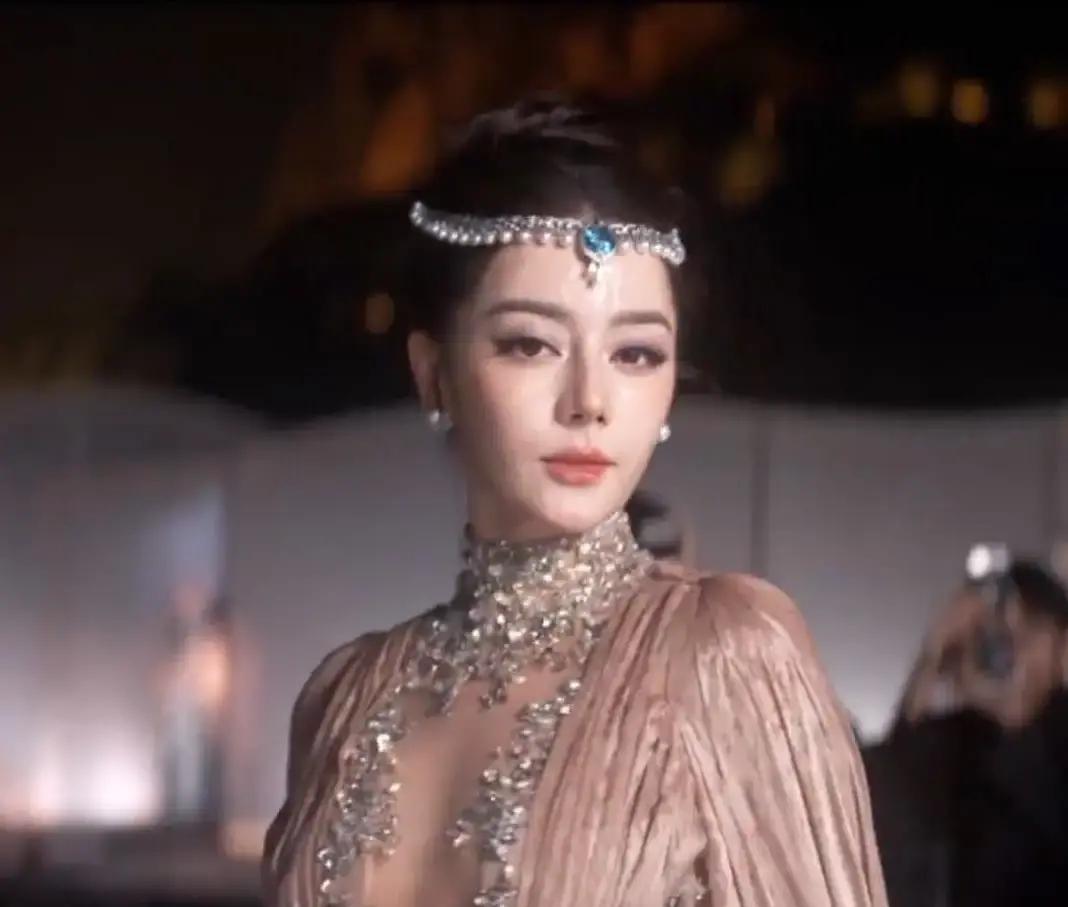 迪丽热巴在苏州雨夜放飞蝴蝶那一幕，很多人以为全靠老天爷赏饭吃，其实换个人早翻车了。
那件高定重达三十来斤，全是手工钉的碎钻，吸了水沉得像铁。穿着细高跟踩在湿滑的地面上，原本贴在唇边的仿真蝴蝶还被雨水给泡松了。
这个造型在巴黎秀场刚亮相时，外媒骂声一片，觉得把蝴蝶粘在嘴上是在搞“噤声”和“压制”。