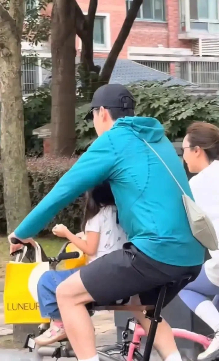 胡歌一家三口上海街头骑行被偶遇，车上载着女儿，还贴心帮妻子背包 ​
