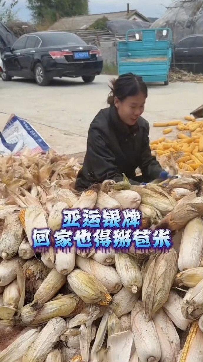 #亚运会夺奖牌回家也躲不过掰苞米#领奖台上光芒万丈，老家院子熟练掰苞米。

荣光不丢本色，身披奖牌，也不忘人间烟火。 ​