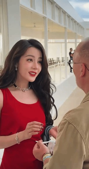 迪丽热巴这女人到底懂不懂自己的杀伤力在哪里？
明明穿得像个随时能接管上市公司的霸气大女主，结果镜头一推近，又秒变幼儿园刚放学的小朋友。
大波浪配一身红裙，大红唇一抹，光看生图就是妥妥的明艳港风，冷艳得让人不敢靠近。
可现场跟品牌方打招呼的时候，她那些摇头晃脑的小动作、还有憋不住笑的微表情，直接
