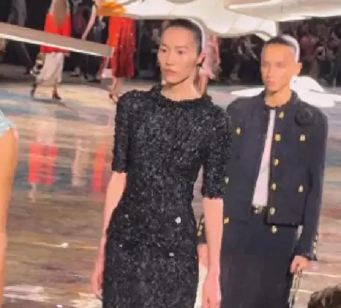 王一博第十一次坐进香奈儿大秀头排，穿的是品牌给他定制的报纸印花大衣。外媒生图放出来，评论区聊的全是他的脸。
2026年10月5日，巴黎时装周香奈儿2027春夏大秀。王一博、辛芷蕾、窦靖童坐在头排看秀。第二天，G社无修生图全网流出。
搜狐的标题写的是王一博脸肿，窦靖童低胸太敢穿，辛芷蕾高开衩惊艳全场。