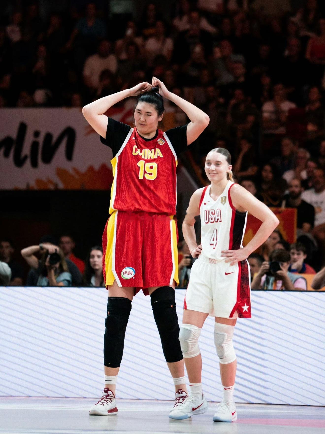 #1米83的佩奇和2米23的张子宇比身高#
女篮世界杯中美大战，赛场名场面来了。

1米83的美国后卫佩奇·布克斯，好奇伸手比划，和2米23的张子宇比身高。张子宇贴心弯腰配合，就算弯下身子，依旧比佩奇高出半个头，40厘米的身高差视觉冲击力拉满。

场上是针锋相对的对手，场下是友好的互动。
本场张子宇拿 ​