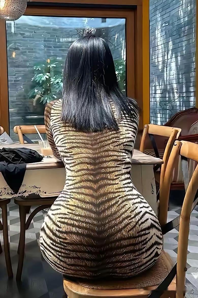 优雅黑发女子背对镜头，身穿豹纹连衣裙，坐在咖啡馆里。不入虎穴焉得虎子