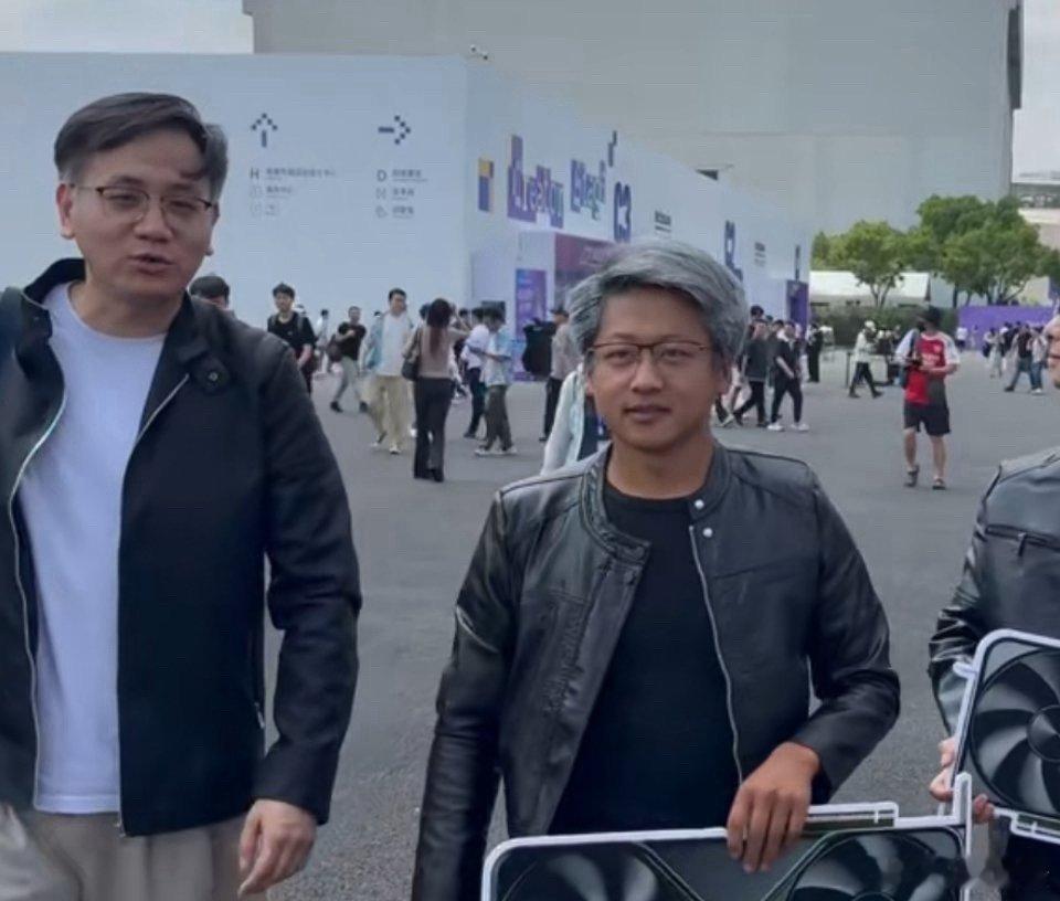 #老外合照半天才发现认错黄仁勋#网红博主“黄银勋”在外滩大会现场，身着黄仁勋标志性的黑色皮衣，手持打印制作的显卡道具，造型复刻度极高。有外籍游客将其误认为是英伟达CEO黄仁勋本人，热情上前合影留念，拍了半天才凑近发现是模仿者，尴尬又欢乐的氛围瞬间拉满 ​