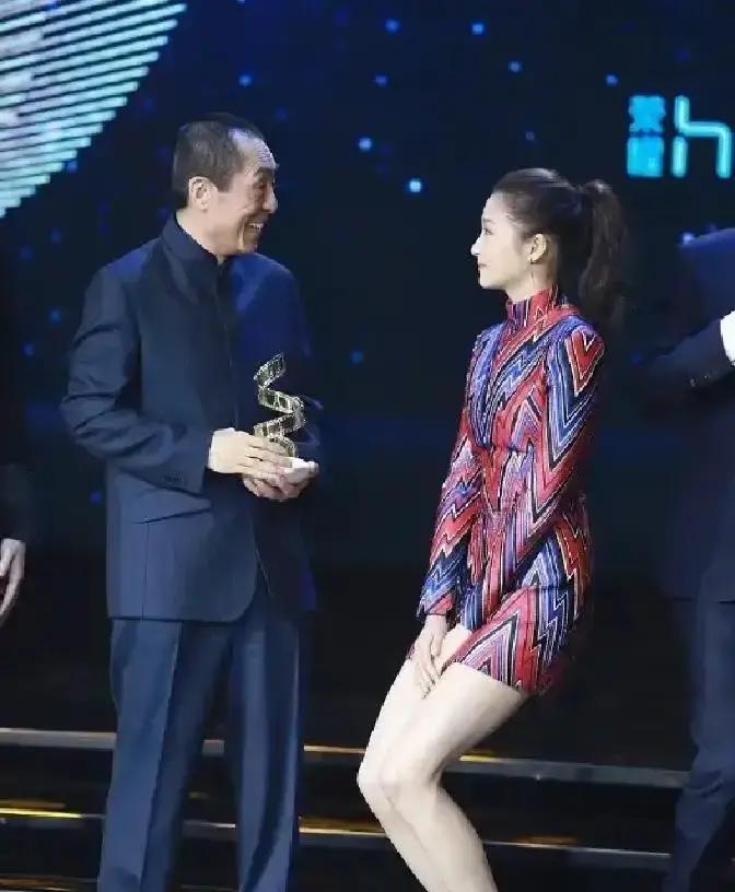 2018年，一次颁奖晚会上，关晓彤偶遇张艺谋，随后赶紧把双腿夹紧，身体下蹲，惹得张艺谋很纳闷，随后关晓彤的一句话，引起现场雷鸣般的掌声，但网友们却一片质疑！
关晓彤蹲下身，迅速将晚礼服的裙摆拢紧，压在了膝盖之间。这个动作让她瞬间矮了一截，视线正好与张艺谋的胸口平齐。张导正要开口，她已经仰起脸，声音清