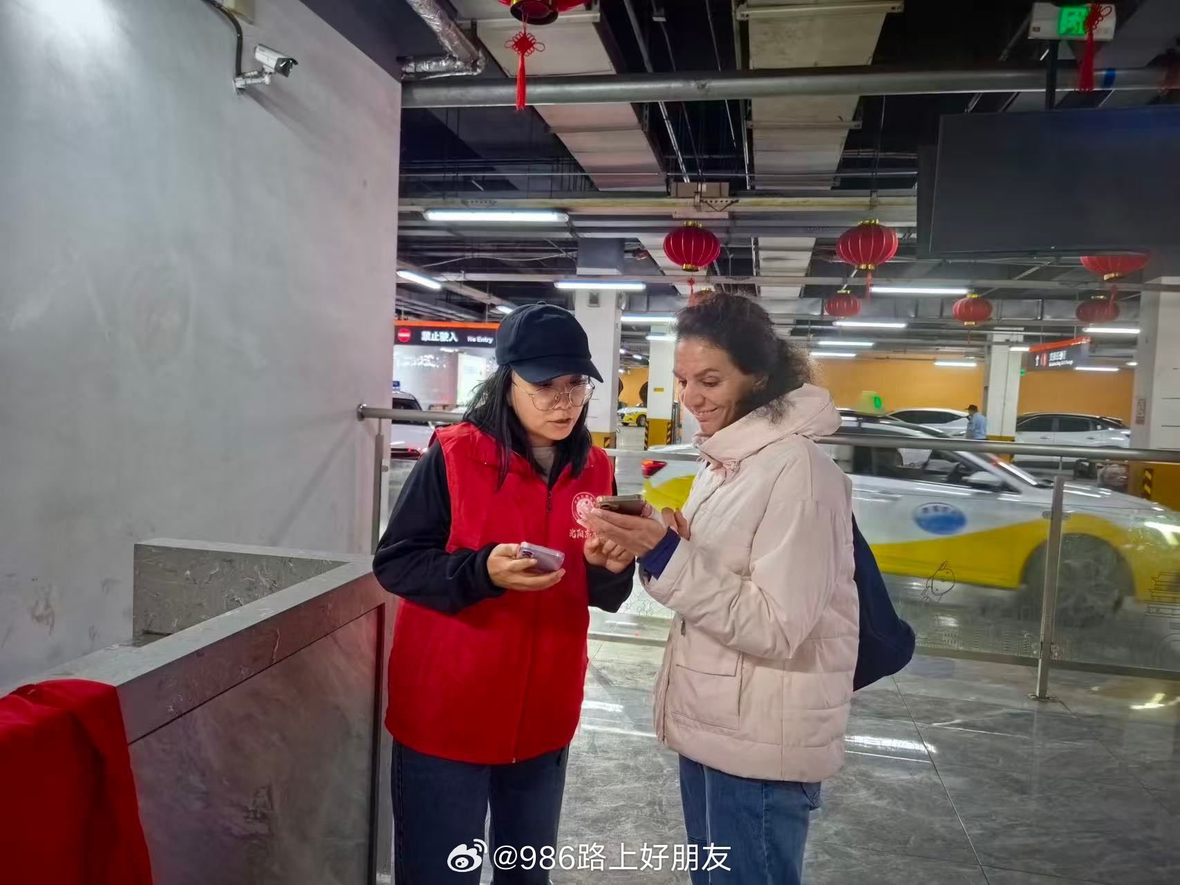 #986路上好朋友[超话]#沈阳市城管执法局在沈阳北站开展假期志愿服务，红马甲志愿者轮班值守，提供热水、路线指引、行李帮扶等便民服务。志愿者还贴心帮扶外籍游客，用英语协助规划行程，推介沈阳文旅资源。一抹“志愿红”践行“党派我来的”承诺，擦亮文明城市名片，用暖心服务守护旅客出行路，展现沈 ​