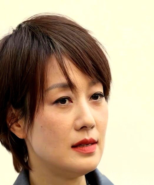 50岁的马伊琍，最近在上海静安嘉里中心露了个面，一张连滤镜都没加的生图，直接撕开了中年女演员的“体面谎言”。
旁边站着的是樊振东、赵今麦这些二三十岁的年轻顶流，她倒好，不躲不藏，套件宽大的灰西装，袖子往上一撸，连眼角的皱纹都没修，却硬生生把全网的目光死死钉在了自己身上。
黑色垂感长裙贴着身子，外面罩