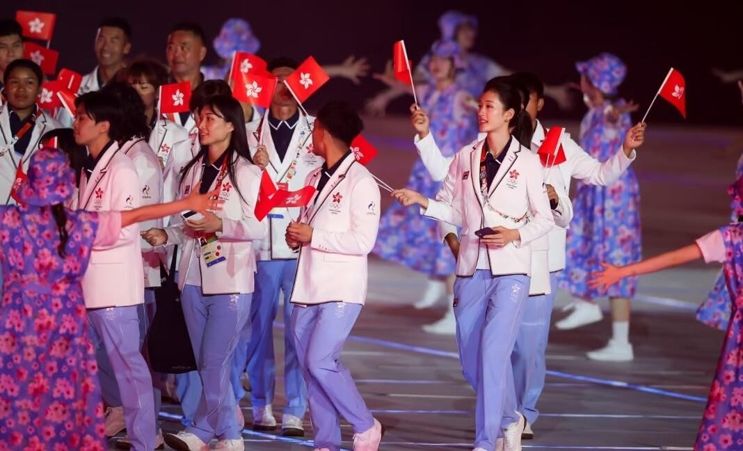 名古屋亚运会开幕式上，中国香港代表团一身白配紫的入场造型直接把社交平台刷屏了。港队穿的是白色上装搭淡紫色长裤，配色干净清爽，在开幕式现场冷清的氛围里格外亮眼，网友直接评价“把赛场走成了秀场”。这套团服由FILA打造，设计上融入了香港城市天际线和狮子山元素。说真的，好看就是好看，不用扯什么情怀滤镜。紫