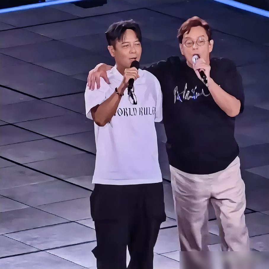谭咏麟正唱着，突然停了。目光往台下一扫，直接点名：李克勤，上来！
没彩排，没准备。李克勤坐在观众席，手里连副眼镜都没带。翻栏杆，跨护栏，真就蹦上了红馆的台。
两人一抱，全场炸了。
接着就是《朋友》。没和声排练，没灯光走位，一张嘴就是几十年的默契。李克勤在台上说，整晚听哭了好几回。
事后他发文